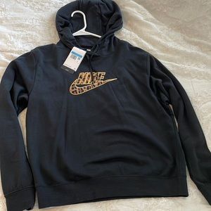 Black pullover hoodie with leopard print font in middle “Nike”.